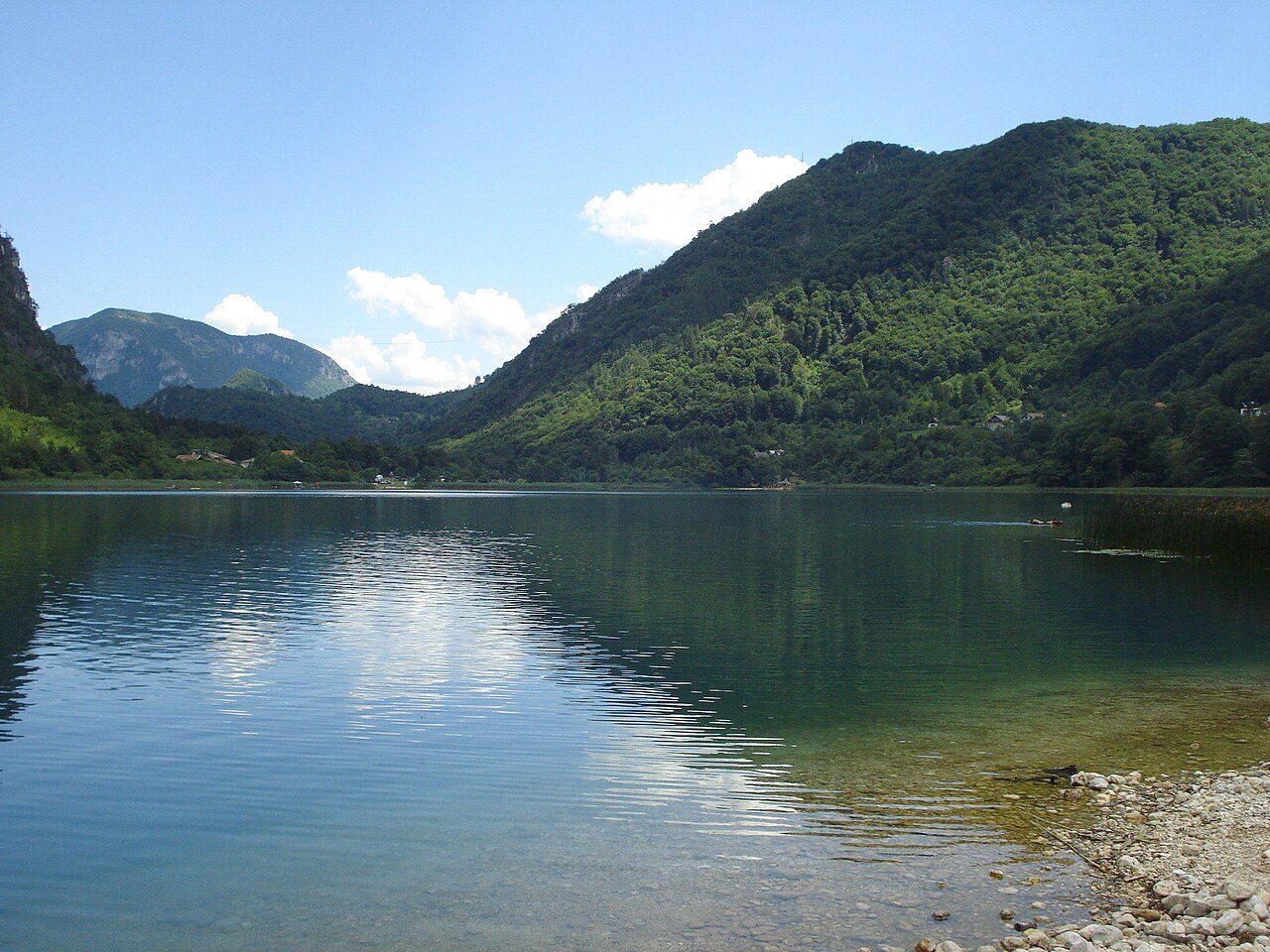Boračko Lake reflecting the forested hills around it