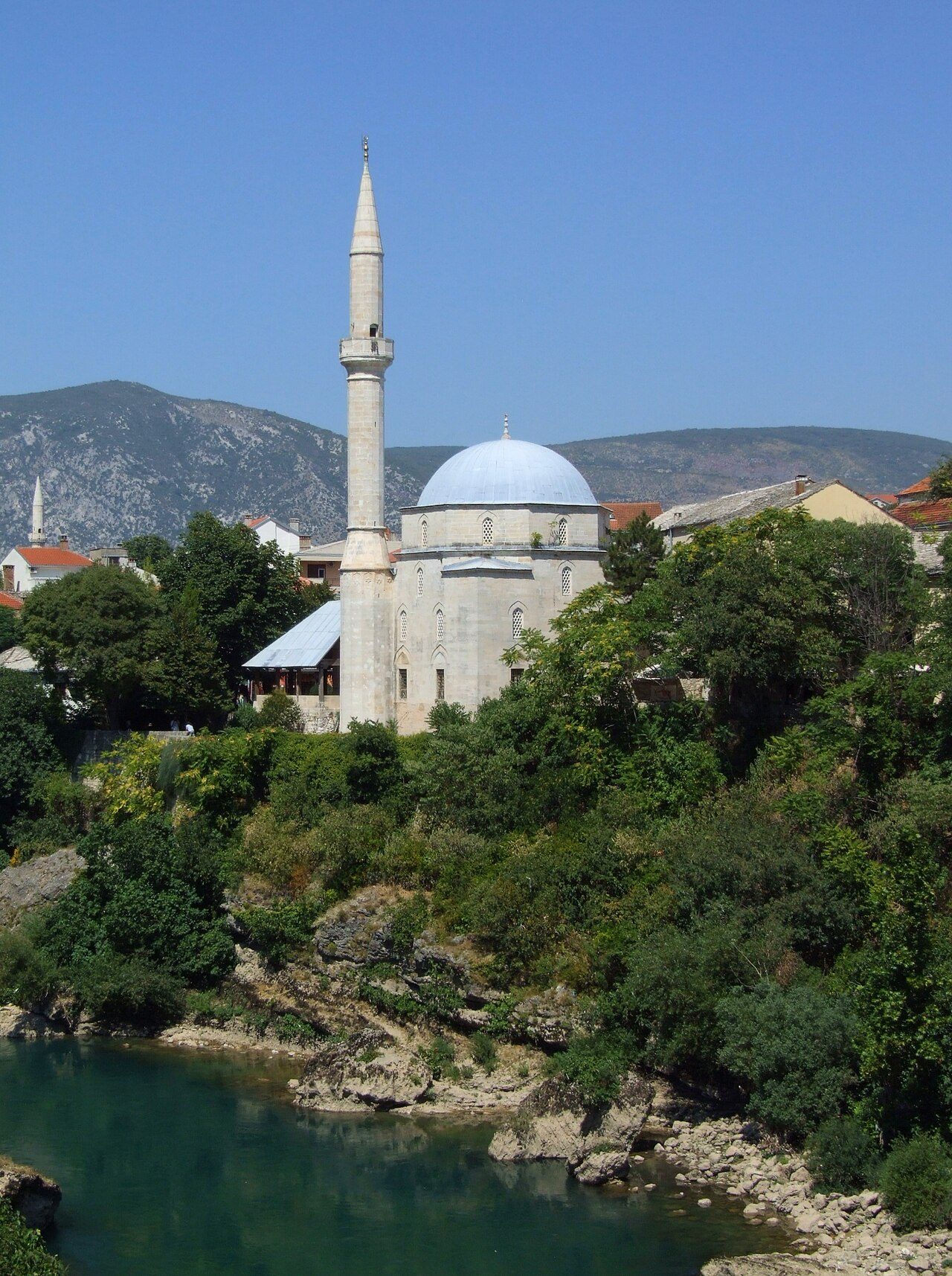 The Koski Mehmed Pasha Mosque and its minaret above the green Neretva in Mostar