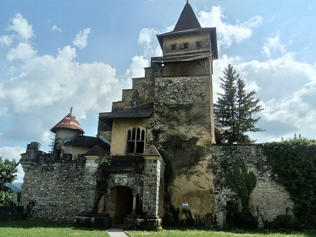 The stone towers and gate of Ostrožac Castle under a blue sky