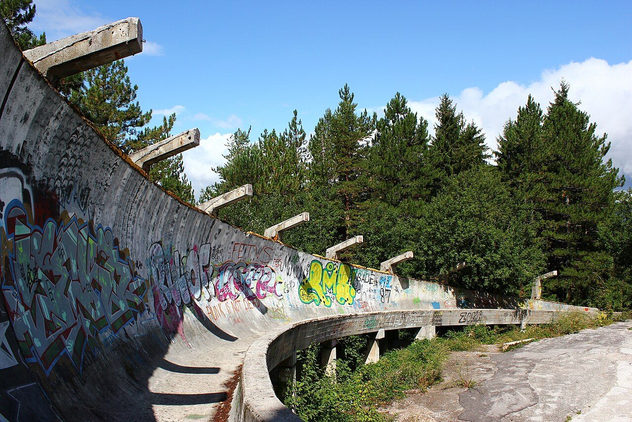 A curve of the abandoned 1984 Olympic bobsled track on Trebević, covered in graffiti among pine trees